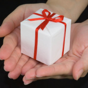 Hands holding a gift box isolated on black background